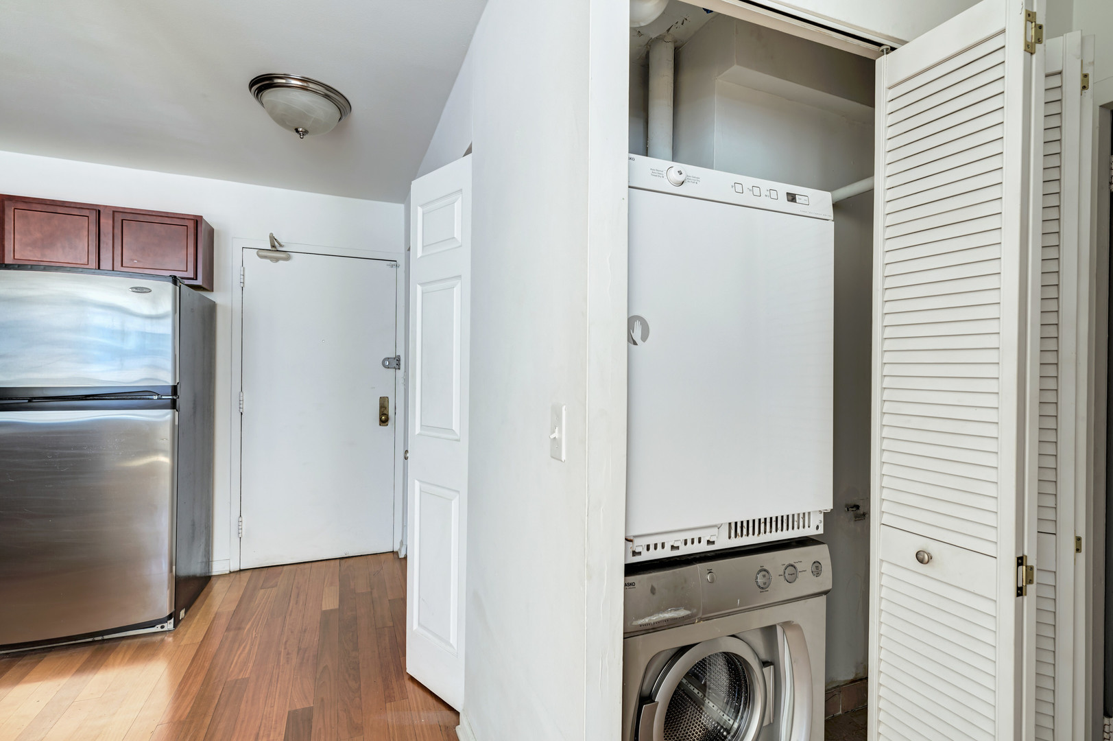 222 East Pearson Street, Unit 203 Chicago, IL 60611 - Photo 5 of 29 a view of kitchen space with refrigerator and wooden floor