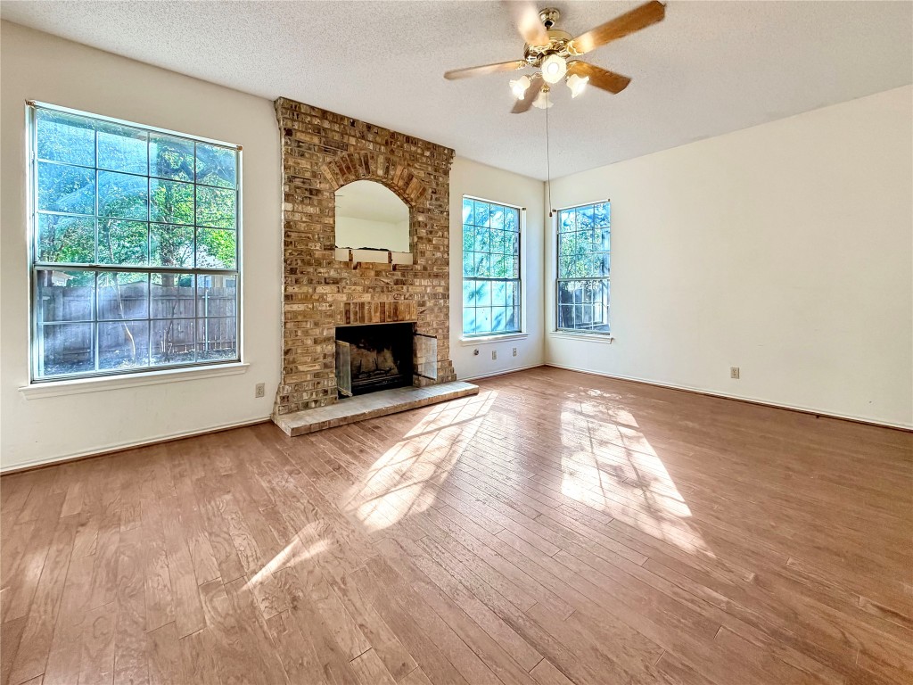1106 Thistle Trail Cedar Park, TX 78613 - Photo 6 of 37 a view of empty room with wooden floor fan and a fireplace