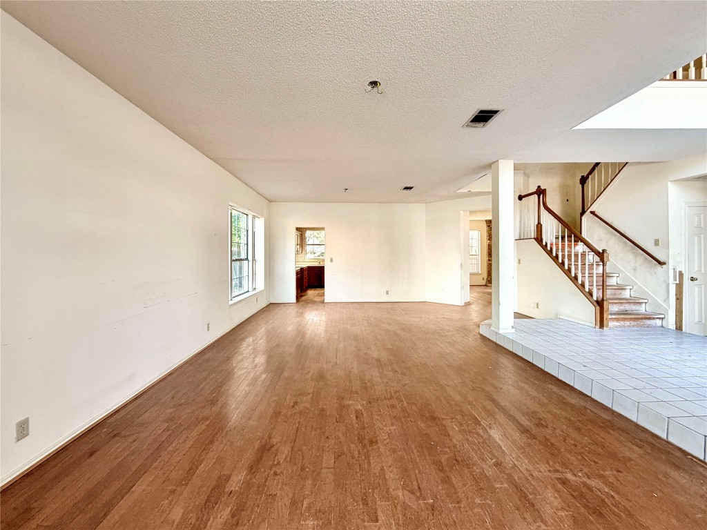 1106 Thistle Trail Cedar Park, TX 78613 - Photo 7 of 37 a view of an empty room with wooden floor and stairs