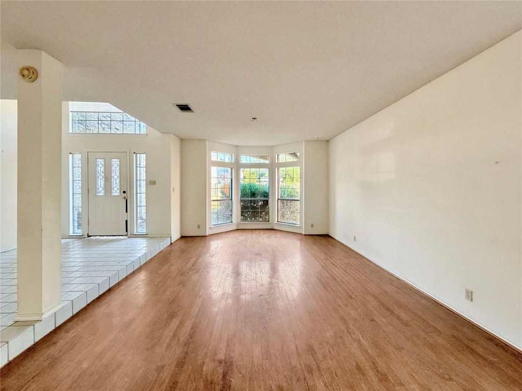 1106 Thistle Trail Cedar Park, TX 78613 - Photo 9 of 37 a view of an empty room with wooden floor and a window