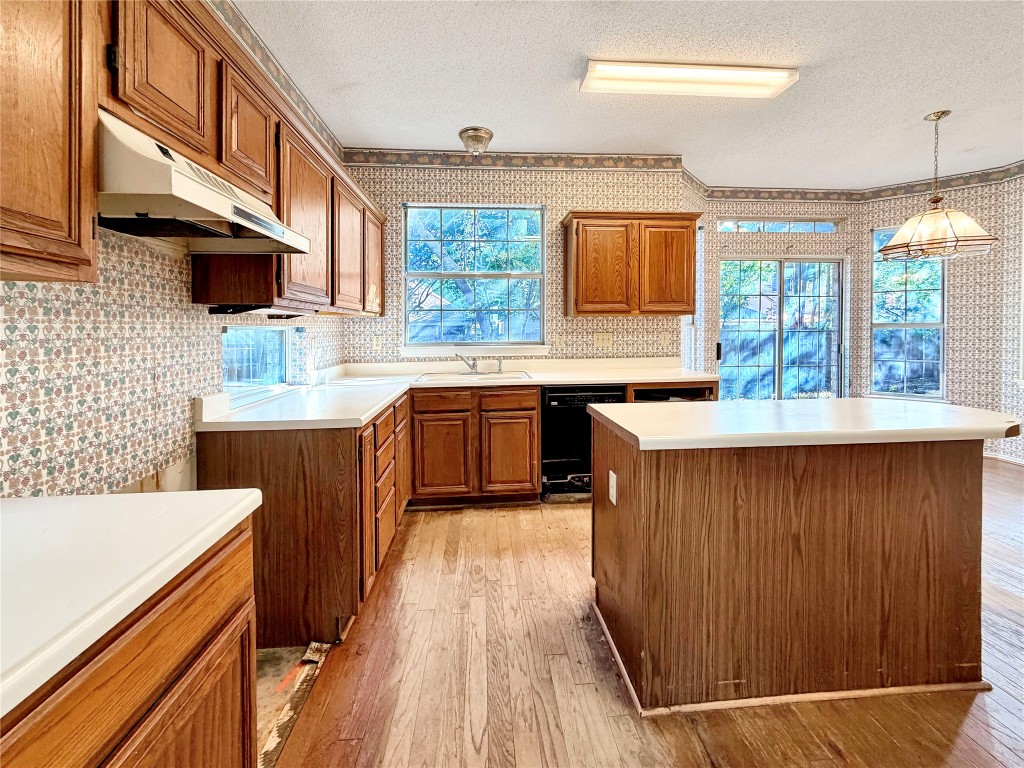 1106 Thistle Trail Cedar Park, TX 78613 - Photo 10 of 37 a kitchen with stainless steel appliances granite countertop wooden cabinets a sink and a wooden floor