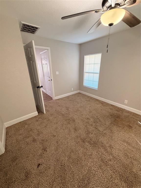 3714 Garden Lane Dallas, TX 75210 - Photo 6 of 7 Carpeted spare room with a ceiling fan and a textured ceiling
