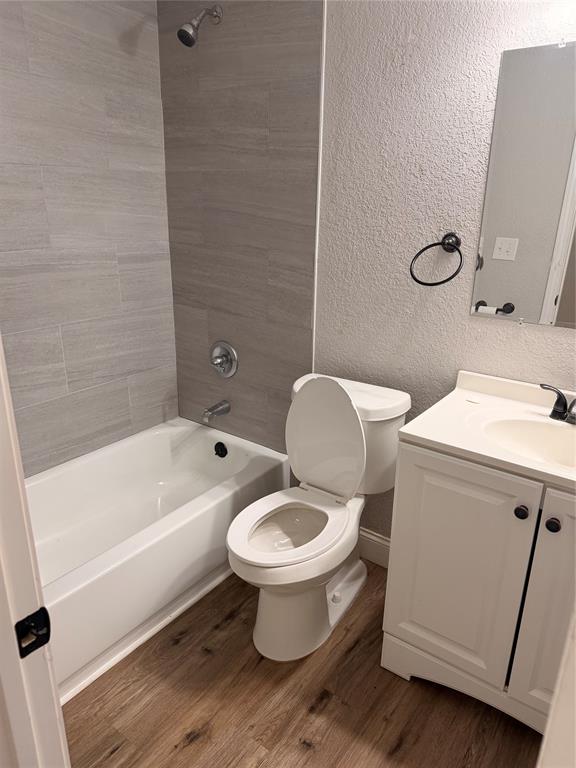 3714 Garden Lane Dallas, TX 75210 - Photo 7 of 7 Full bathroom featuring vanity, shower / washtub combination, a textured wall, and dark wood-type flooring