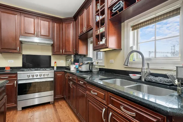a kitchen with granite countertop a stove and a sink