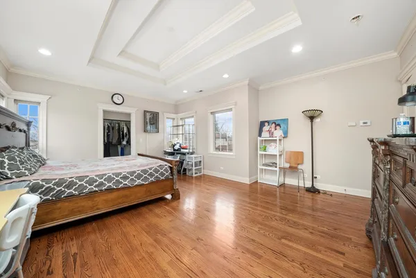 a spacious bedroom with a large bed and a wooden floor