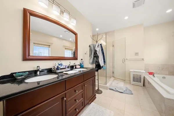 a spacious bathroom with a double vanity sink a mirror and a shower