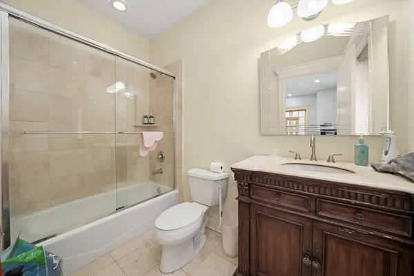 a bathroom with a granite countertop sink toilet a mirror and shower