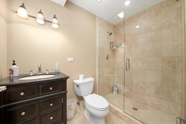 a bathroom with a granite countertop toilet sink and mirror