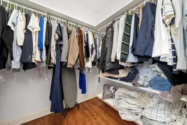 a view of walk in closet with clothes