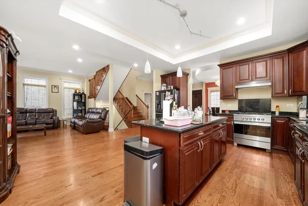 a kitchen with stainless steel appliances granite countertop a stove and a wooden floors