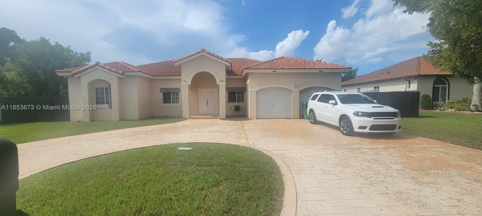13281 Southwest 206th Terrace Miami, FL 33177 - Photo 1 of 18 a front view of a house with a yard and garage