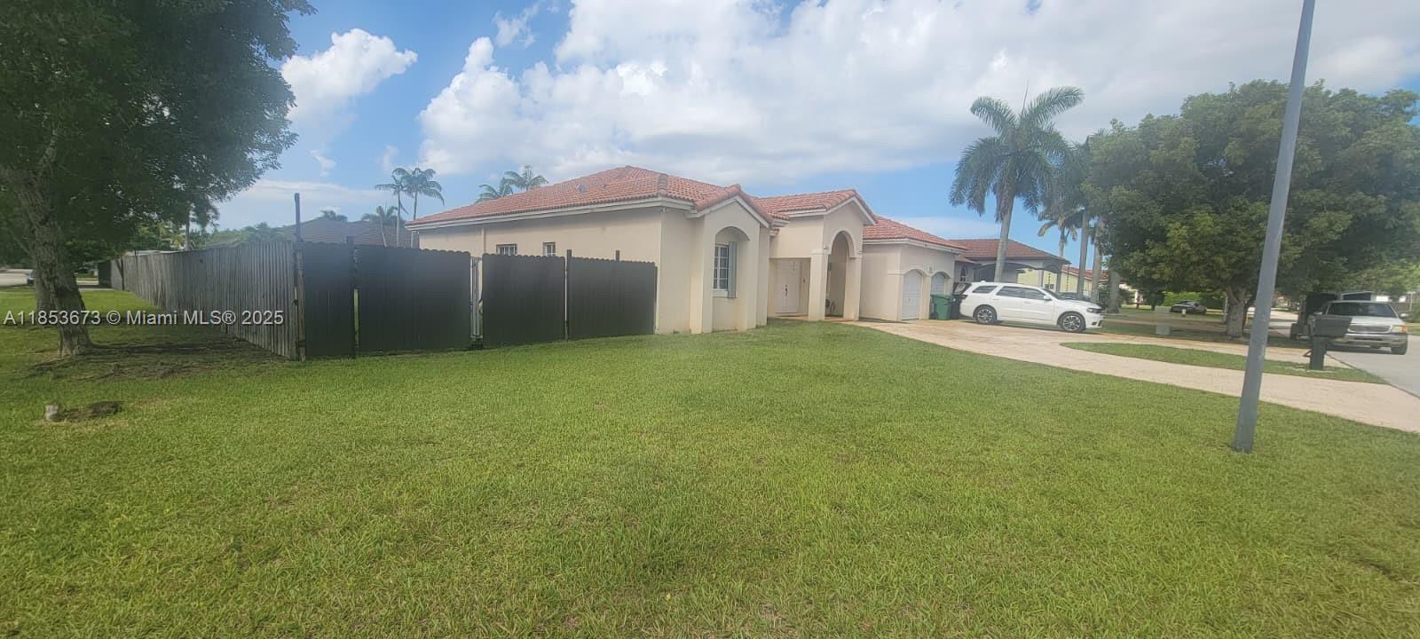 13281 Southwest 206th Terrace Miami, FL 33177 - Photo 17 of 18 a front view of a house with a yard and garage