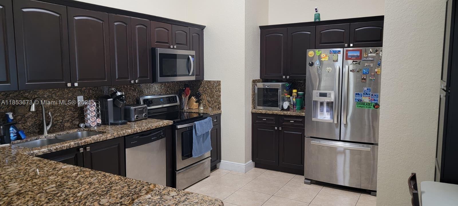 13281 Southwest 206th Terrace Miami, FL 33177 - Photo 3 of 18 a kitchen with stainless steel appliances granite countertop a refrigerator and a stove