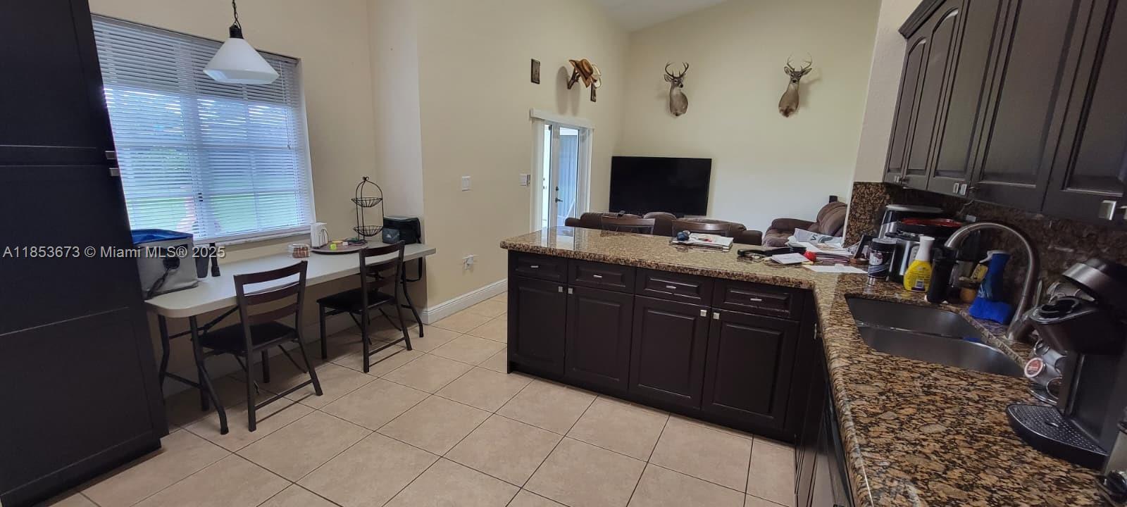 13281 Southwest 206th Terrace Miami, FL 33177 - Photo 4 of 18 a kitchen with a stove a sink and a refrigerator with wooden floor