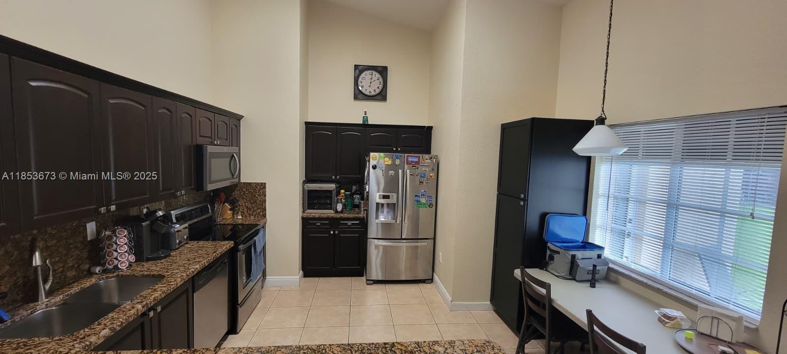 13281 Southwest 206th Terrace Miami, FL 33177 - Photo 5 of 18 a kitchen with a refrigerator wooden floor and a stove top oven