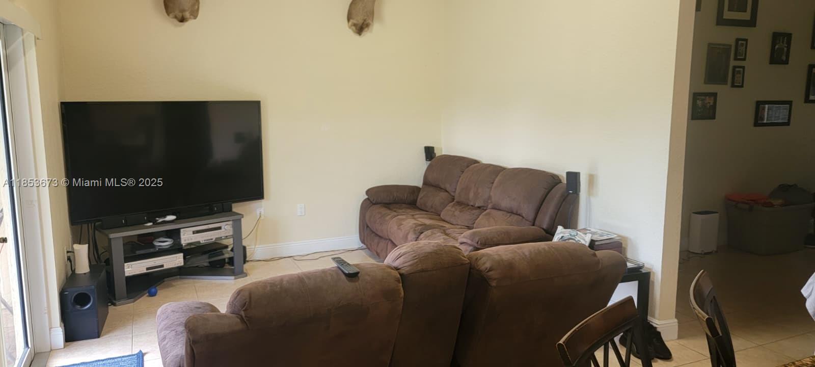13281 Southwest 206th Terrace Miami, FL 33177 - Photo 6 of 18 a living room with furniture and a flat screen tv