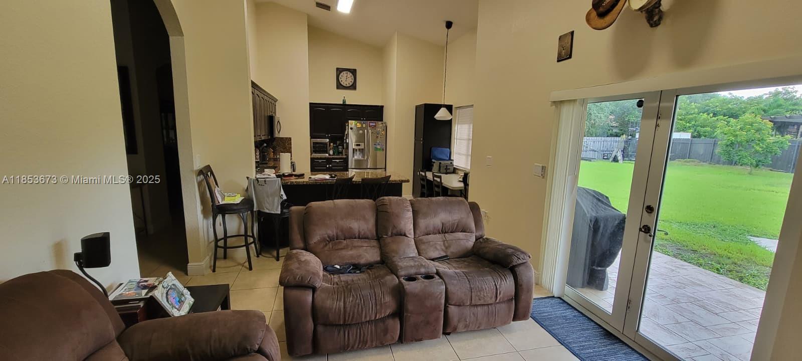 13281 Southwest 206th Terrace Miami, FL 33177 - Photo 9 of 18 a living room with furniture floor to ceiling window and a fireplace