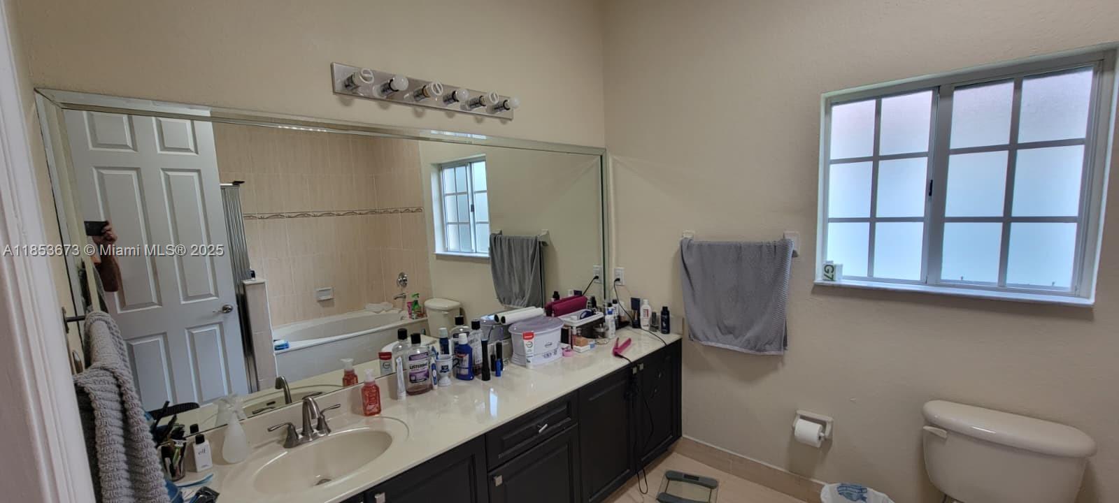 13281 Southwest 206th Terrace Miami, FL 33177 - Photo 10 of 18 a bathroom with double vanity sink a mirror and a toilet