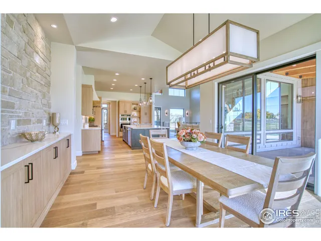 a dining hall with stainless steel appliances kitchen island granite countertop a table and chairs