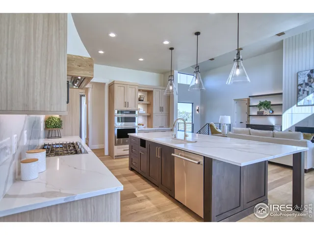 a kitchen with stainless steel appliances kitchen island granite countertop a sink a stove and a wooden floors