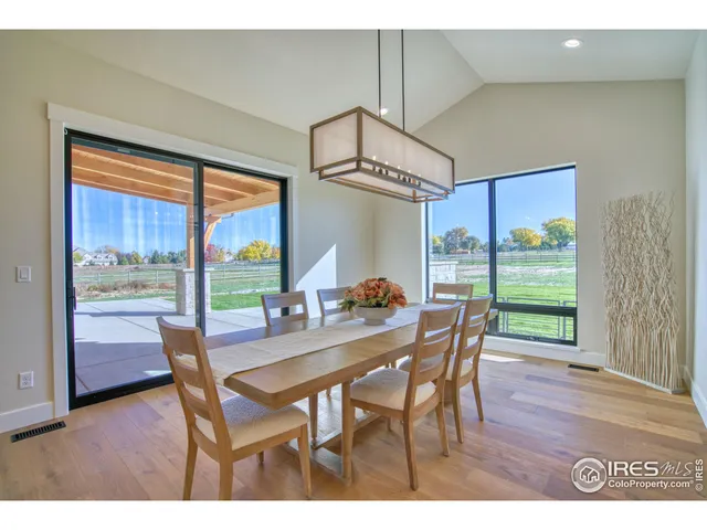 a dining room with furniture a chandelier and wooden floor