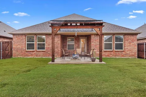 a view of a house with a yard and sitting area