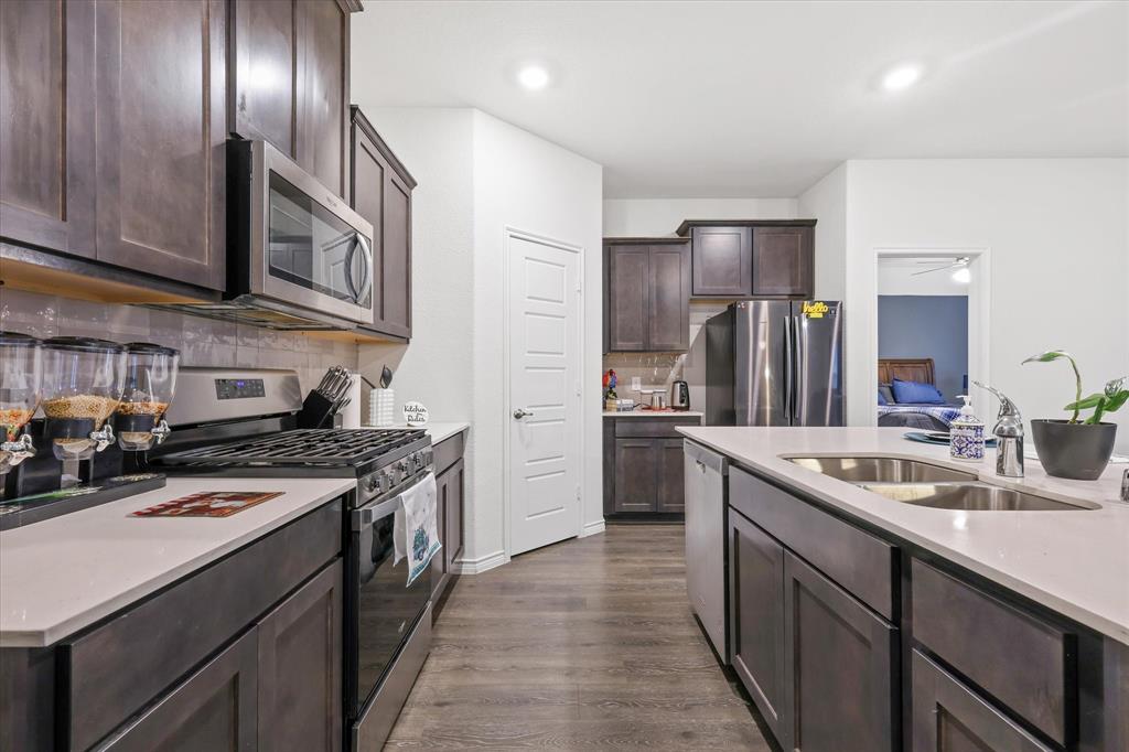 1653 Albatross Road Princeton, TX 75407 - Photo 7 of 18 a kitchen with stainless steel appliances granite countertop a sink a stove and a refrigerator