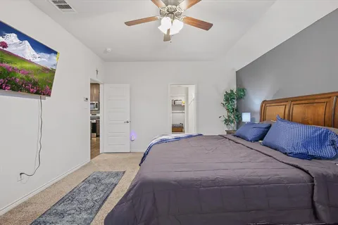a bedroom with a large bed and a chandelier
