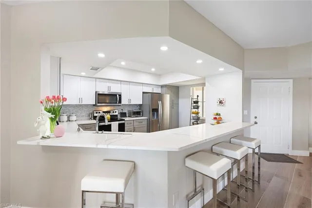 a kitchen with stainless steel appliances kitchen island granite countertop a sink and cabinets