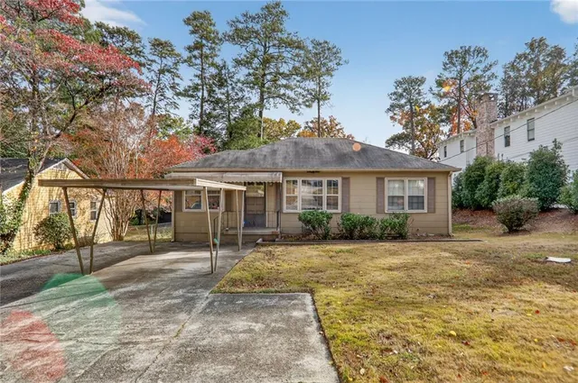 a view of a house with backyard and a tree