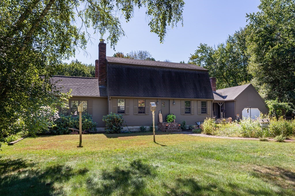 a view of a house with backyard and trees