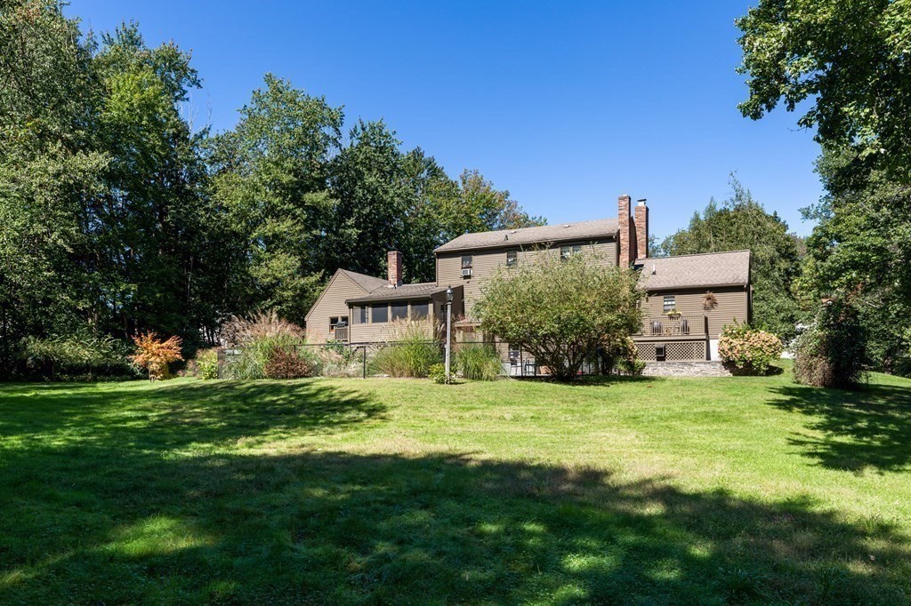 4 Chestnut Street Hopkinton, MA 01748 - Photo 29 of 40 a white house with a small yard and large trees