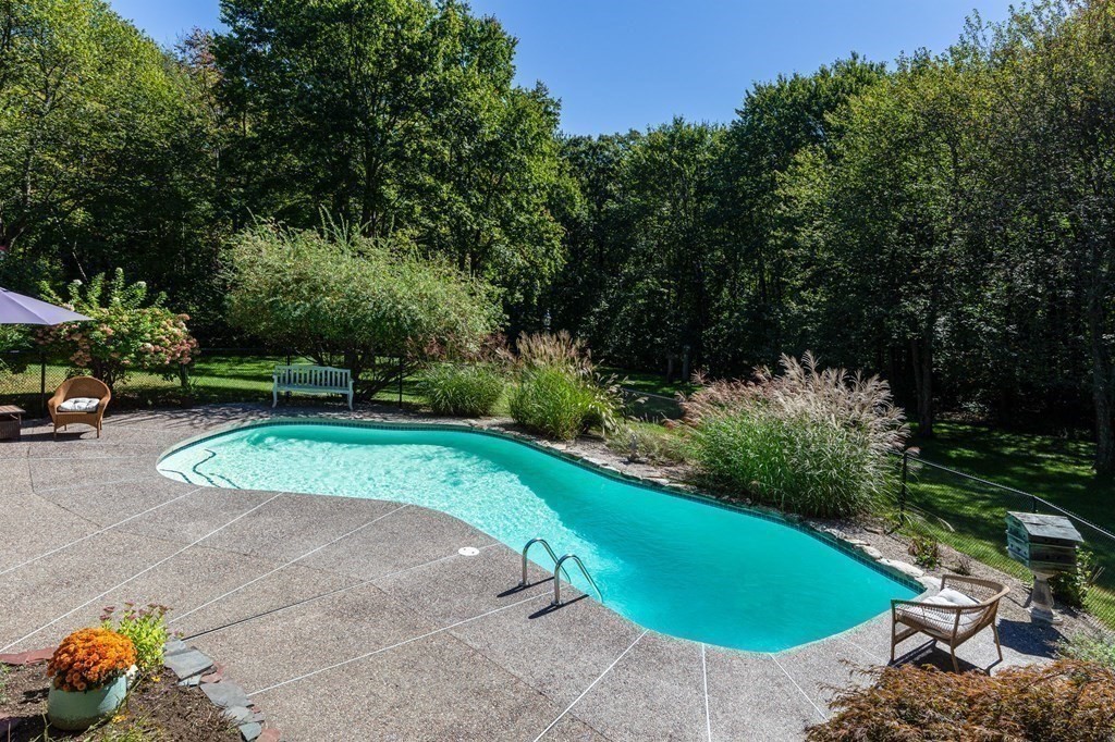 4 Chestnut Street Hopkinton, MA 01748 - Photo 32 of 40 a view of a swimming pool with a outdoor seating and a forest