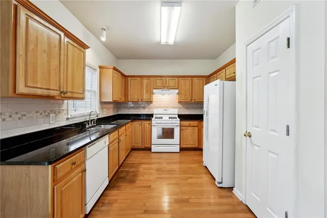 a large kitchen with stainless steel appliances granite countertop a stove a sink and a refrigerator