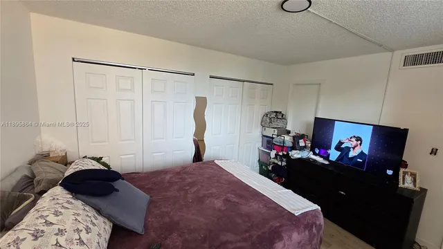 a bedroom with a bed and a flat screen tv