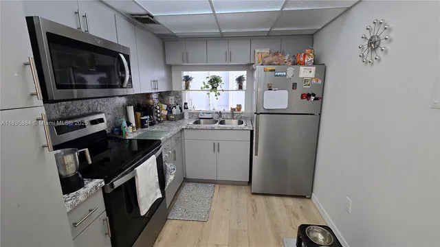 a kitchen with a refrigerator a stove a microwave and cabinets
