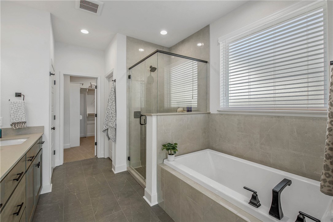 5010 Acadia Loop Bryan, TX 77802 - Photo 18 of 21 a bathroom with a tub a sink and a large mirror