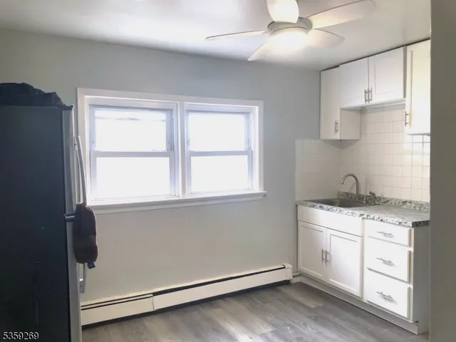 a kitchen with a stove cabinets and wooden floor