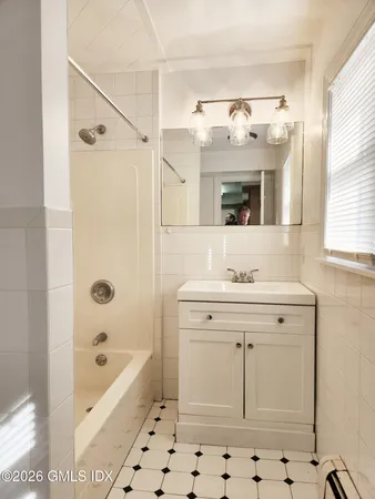 a bathroom with a sink mirror and a bathtub