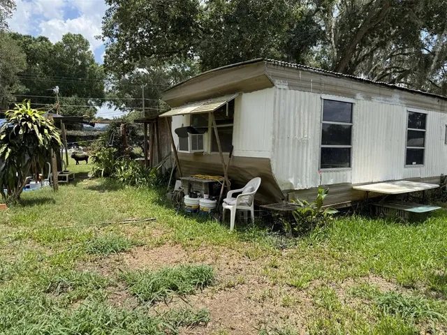 a backyard of a house with yard and outdoor seating