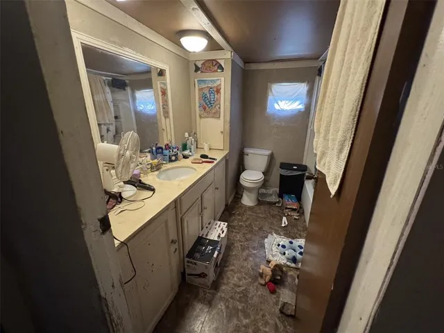 a bathroom with sink and mirror with toilet