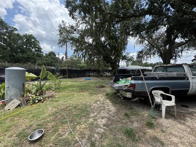 a view of a backyard with chairs and a fire pit