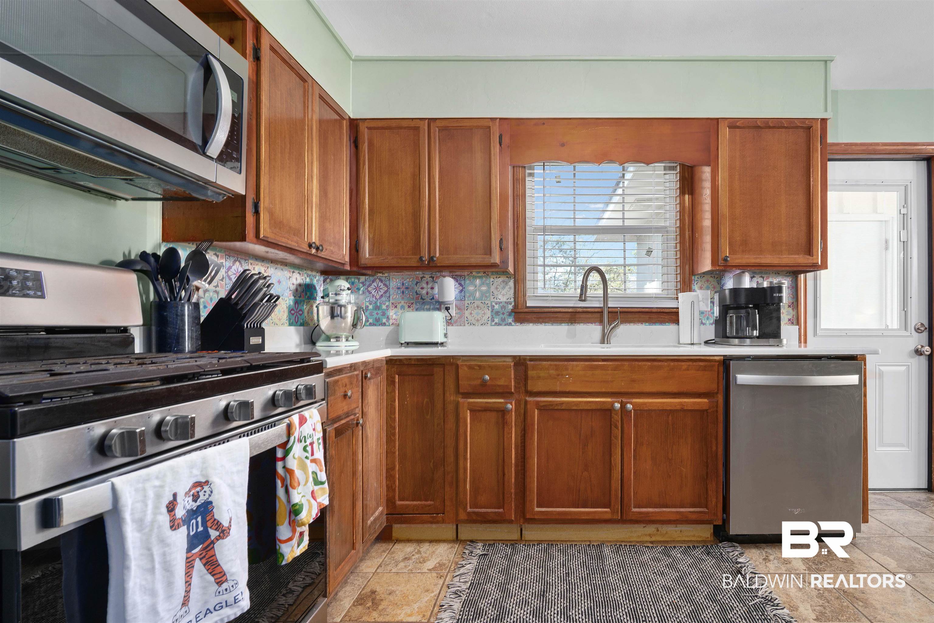 672 Tarawa Drive Mobile, AL 36609 - Photo 10 of 26 Kitchen featuring stainless steel appliances, light countertops, wood finish cabinets, and decorative backsplash