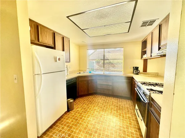a kitchen with stainless steel appliances granite countertop a refrigerator a stove and white cabinets