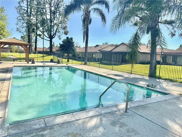 a view of swimming pool with a table and chairs under an umbrella