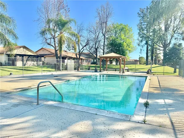 a view of pool with a table and chairs under an umbrella