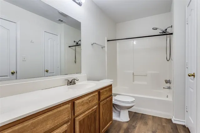 a bathroom with a sink a toilet and a large mirror