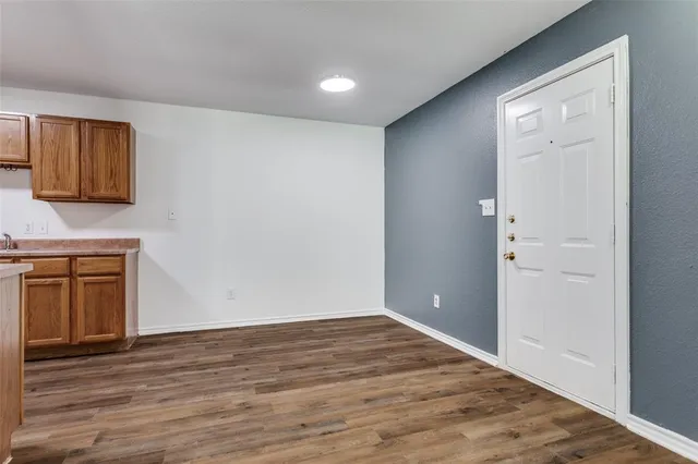 a view of empty room with wooden floor and cabinet