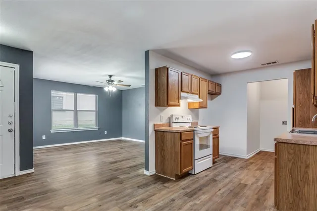 a kitchen with a stove and wooden floor