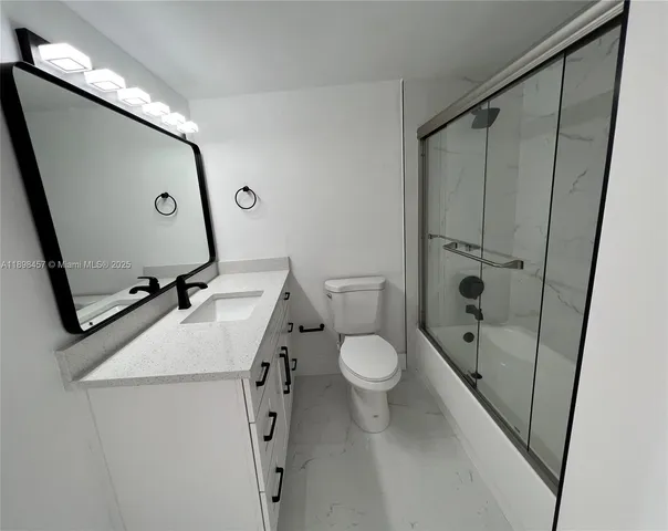 a bathroom with a sink a toilet a mirror and shower